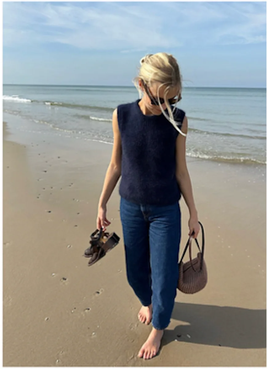 Person wearing a navy Friday Slipover while walking on the beach